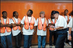 Sue Pippin of BMS Catastrophe, a disaster-recovery company based in Forth Worth, Texas, writes the names of day workers assigned to help clean a water-damaged building on the campus of Bonnabel High School.