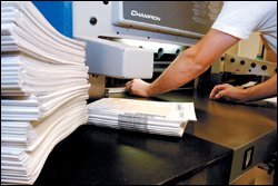 A worker inserts bundles of tests into a binding-removal machine.