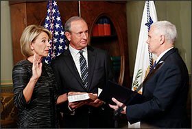 Vice President Mike Pence, right, swears in Education Secretary Betsy DeVos in the Eisenhower Executive Office Building in Washington on Feb. 7. DeVos' husband, Dick DeVos, is at center.