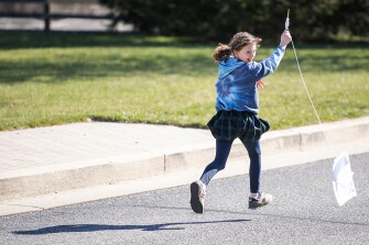 The school incorporates a daily 25-minute exercise break each morning where students rotate between different activities. Here, Anna, 9, flies a DIY kite outside.
