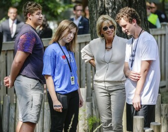 Zoo School students wearing “I Love Public Schools” T-shirts meet with the secretary during her tour.