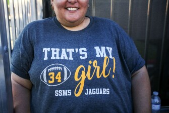 Sharon Michael, mother to football player and band member Julie Michael, shows off her shirt during the school’s first game of the season.