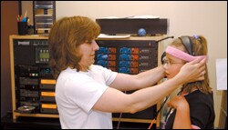At the Center for InnerChange in Greenwood Village, Colo., therapist Cheryl Mock adjusts headphones for Madison Yetter for an alternative treatment for ADHD that involves listening to music.