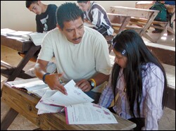 Pedro Pahuamba helps Cynthia Jimenez with language arts homework from her independent-study packet, while visiting La Nopalera, Mexico. The 3rd grader was slated to be absent 11 days from Kelseyville Elementary School in Northern California.