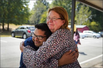 Adrian Galvan, a member of the RISE program and a bilingual paraprofessional at Lyman Hall Elementary School, hugs his former 2nd-grade teacher and teaching inspiration, Donna Garlinghouse, at the school where they both work in Gainesville, Ga.
