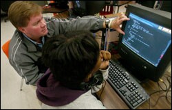 Computer-science instructor Paul J. Ackerman helps 9th grader Jasmine Grant with her Bacteria Bash project during a video-game design class at Edgewater High School in Orlando, Fla.