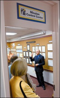 John G. Fryer, the superintendent of the Duvall County, Fla., schools, leads visitors on a tour of the Mission Control room.