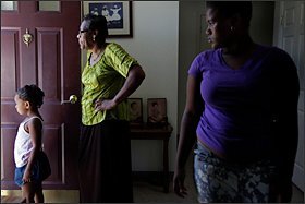 Molene Martin, 60, waits for the rest of the family to return home with her granddaughter Teagan Diggs, 4, left, and adopted grandniece Raqell Martin, 15, in the Cherry Hill neighborhood of Baltimore. For more than seven years, she has been raising her four grandnieces, now ages 9 through 16, and recently her 15-year-old grandson came to live with her, too.