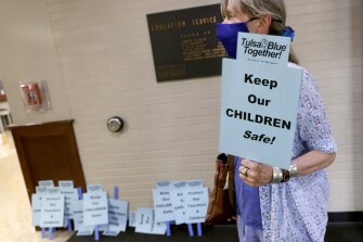 Tulsa resident Holly Sweet, who supports wearing masks, walks into the The Charles C. Mason Education Service Center before a TPS school board meeting in Tulsa on Wednesday, Aug. 11, 2021. Visitors to the meeting were not allowed to carry signs into the meeting room.