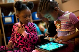 Demayah Clark, 4, right, and Anyjah Franklin, 4, work with tablets at the Crescent Early Learning Center in Pittsburgh’s Homewood neighborhood.