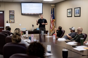 Officer Logan Brown discusses de-escalation tactics with educators from the Benjamin Logan Local School District in Bellefontaine, Ohio, during a training session for the district's armed response team by the Logan County Sheriff’s Office on June 26, 2023. The 24-hour training curriculum is approved by the Ohio School Safety Center, part of the Ohio Department of Public Safety.