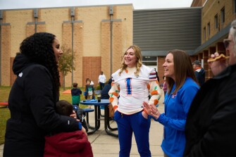 Monica Asher talks to faculty members before a football game during a tailgate party on staff appreciation night.