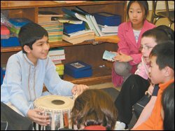 Fifth grader Kush Dave, left, answers questions from his classmates about the tabla drum and his native India during an enrichment cluster at South Grove Elementary School in Syosset, N.Y.