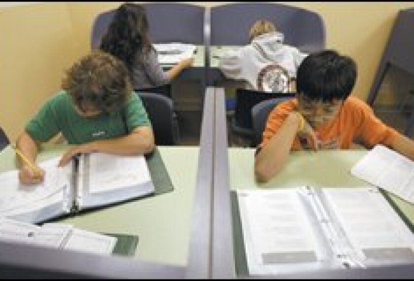 Alexander Tran, right, 13, brushes up on his language arts skills at the Woodland Hills branch of the Huntington Learning Center on a Monday night.