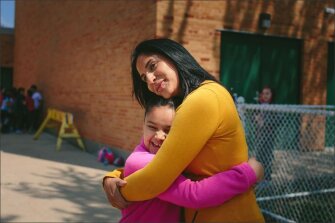 Assistant Principal Alexandra Escobar hugs 2nd grader Analise Rivera, during recess at R. H. Lee Elementary School in Chicago. Escobar is leaving the school, located in a predominantly Hispanic neighborhood on the city’s West Side, for a job in a suburban district.