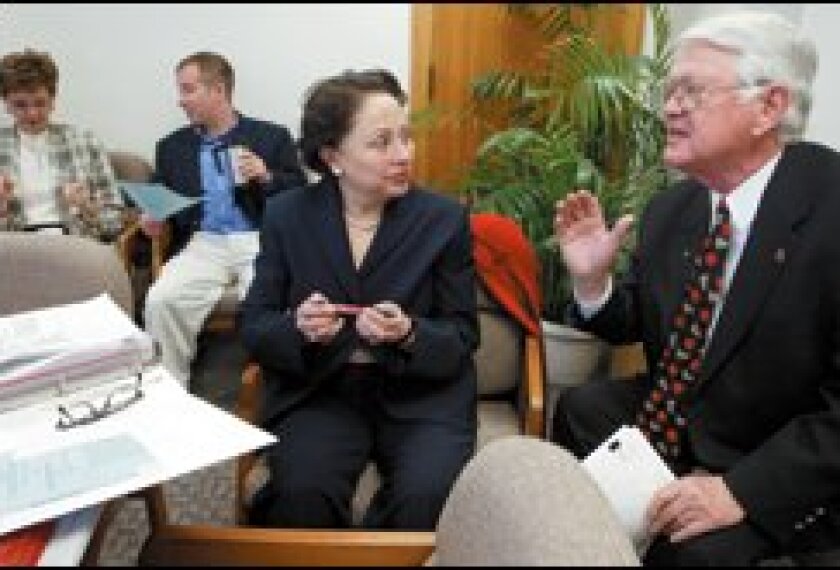 Wayne G. Sanstead, North Dakota schools chief, talks to visiting Department of Education official Ana Garcia in Bismarck.