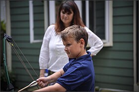 Deborah Lynam, a founding member of Decoding Dyslexia NJ, watches her son Hudson, 11, shoot a bow and arrow at their home in Haddon Heights, N.J. The grassroots organization is now active in all 50 states.
