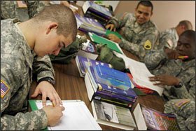 Pvt. Derek Thomas, left, works on a group project in Christin Bradshaw’s reading and writing class at the APS, where GED practice books are the main texts but teachers are given flexibility in their classrooms.