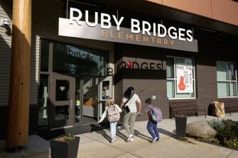 Students are greeted as they arrive for the start of the school day at Ruby Bridges Elementary School in Woodinville, Wash., on April 2, 2024.