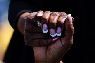 People hold hands as they pray outside the scene of a shooting at a supermarket in Buffalo, N.Y., Sunday, May 15, 2022.