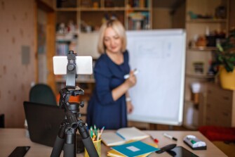 Image of a teacher using a phone to teach a lesson.