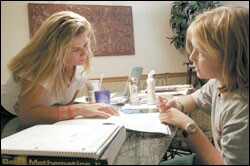 Laurie Taylor helps her daughter Hannah Cummings with homework. The Fayetteville mother questioned the suitability of certain books in the middle and high school libraries, and she formally challenged three titles.