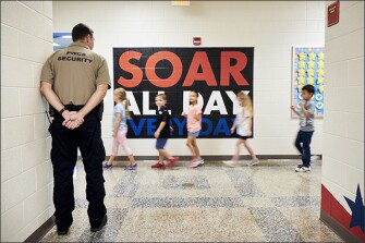 Brian Hall, a community safety officer dedicated to the elementary schools in the Prince William County school system, monitors hallways at Ashland Elementary School in Manassas, Va.