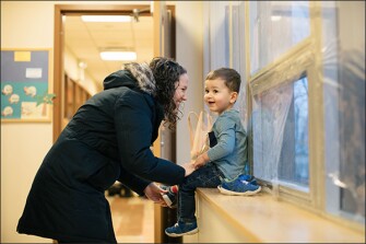 High school English teacher Ashley Amelianovich says goodbye to her son Miles, who is almost 2 years old, at the day-care center housed at her high school in Skokie, Ill. District leaders see the child-care center as a teacher-retention tool.