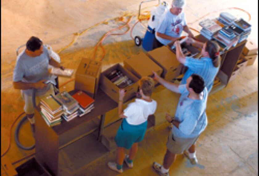 Staff members at Metairie Park Country Day clean school library books damaged in the wake of Hurricane Katrina. All but about 200 of its 31,000 books were saved.