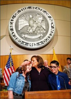 New Mexico Gov. Susana Martinez kisses 8th grader Kendal Sanders during her State of the State address at the New Mexico state capitol in Santa Fe, N.M., Tuesday, Jan. 20, 2015. Sanders and class mate, Nathaniel Tavarez, right, were shot and injured at Berrendo Middle School in Roswell, N.M., last year.