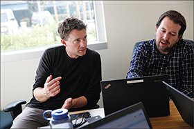 Adam Carter, left, meets with Mike Dunham, right, and other members of the information team at Everest High School. The network is working to bridge the gap between educators and technologists.