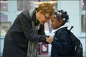 Director of Student Supports Kaleigh Donnelly, left, greets Brianna Thompson, 5, a kindergartner at Memphis College Prep. Students in the charter school are required to look instructors in the eye and pass a visual inspection before entering each day.