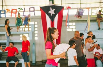 Aliancy Arana, 13, passes by the flag of Puerto Rico at the read-aloud event at Maria Vasquez de Umpierre School in Bayamon.