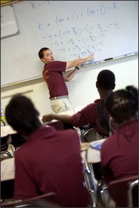 Ryan Eggert, a teacher at William T. Sherman Elementary School, reviews a mathematics problem with students. Mr. Eggert said he “looped” with his students—staying with some of them for two or three years—in order to build stronger bonds with them.