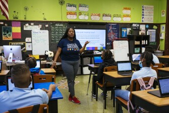 Stephanie Miller-Henderson, 42, teaches sixth grade students how their grades are calculated during a Success Bound lesson at John M. Smyth School on Monday, Dec. 12, 2022 in Chicago, Ill. Success Bound aims to teach middle school students skills they will need in high school and beyond.