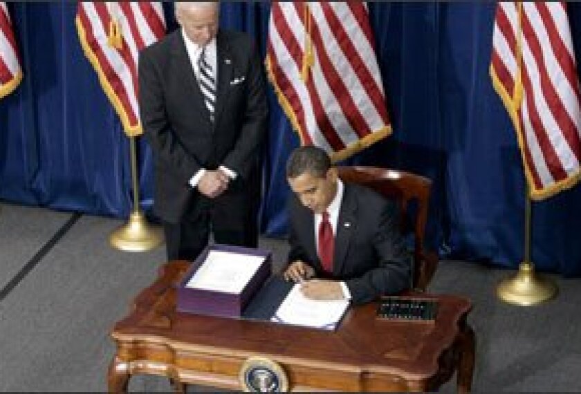 Vice President Joe Biden looks on as President Barack Obama signs the economic stimulus bill during a ceremony on Feb. 17 at the Museum of Nature and Science in Denver.