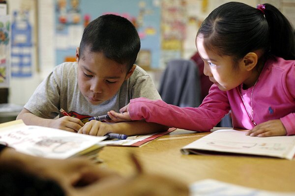 Kindergarten students Martin Byjoe, left, and Shannus Becenti draw in their Navajo journals.