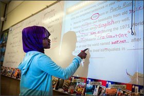 Yasmin Musa, a student from Somalia, works at a whiteboard in an English-language-development class at Meadow Park Middle School in Beaverton, Ore.