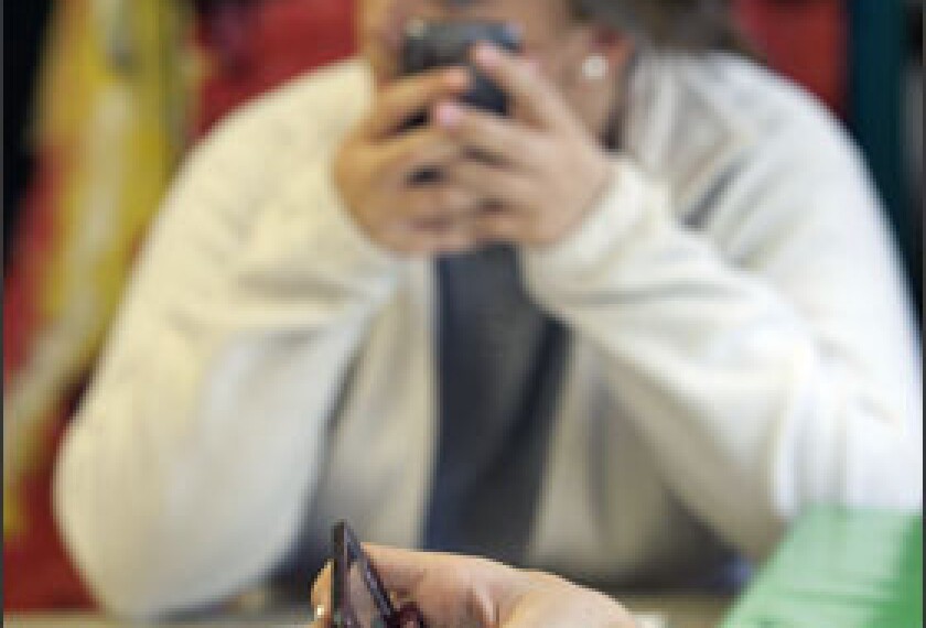 Kayla Boone, a sophomore at Oak Hills High School, in suburban Cincinatti, and her classmates use their cellphones to text answers to questions during an English class. The answers are displayed on a class whiteboard.